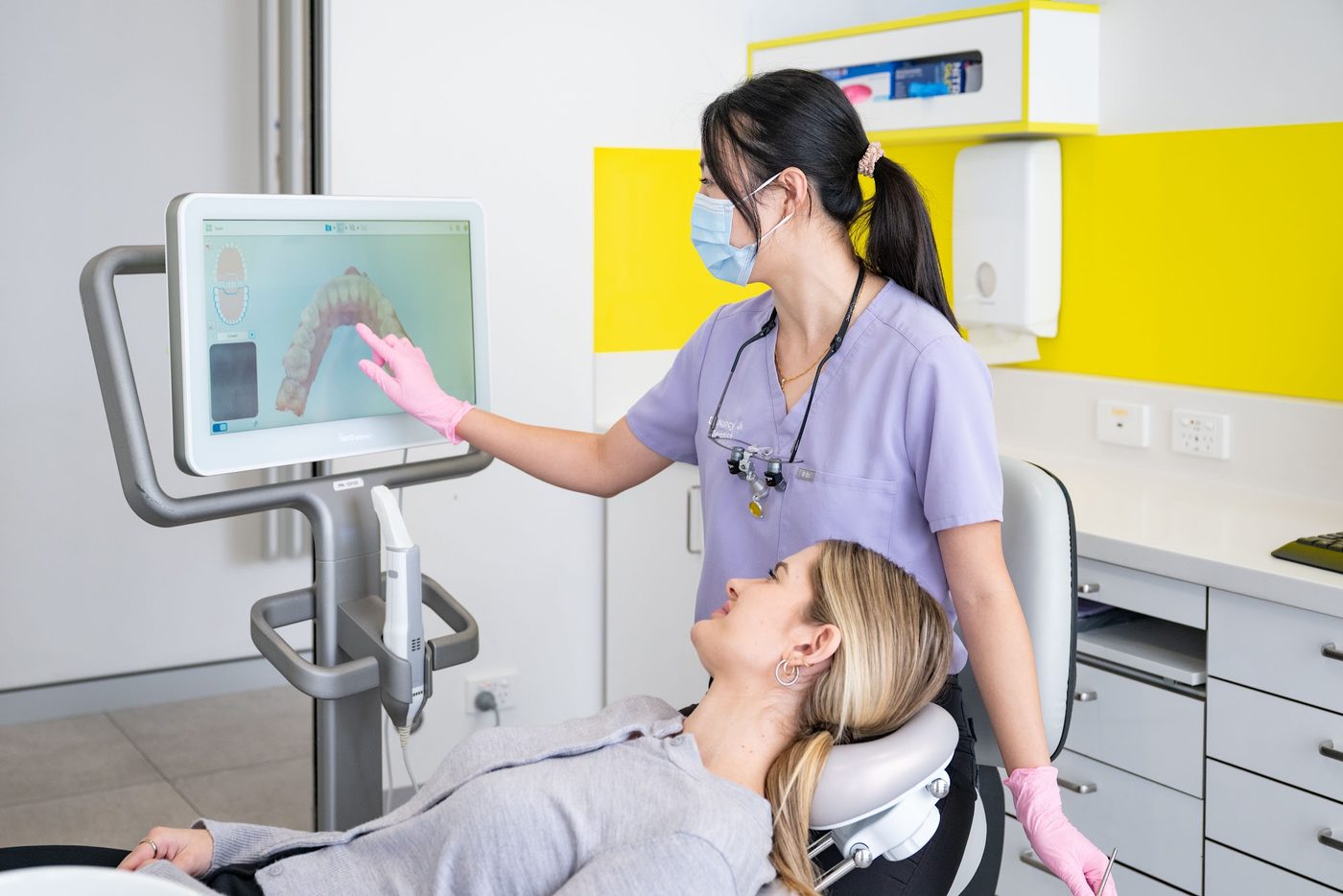 A Glo Dental dentist showing a patient a scan of her teeth